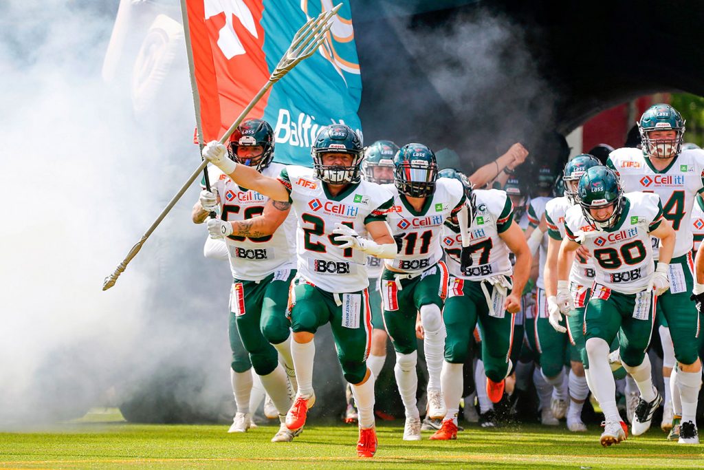 Das Team der Baltic Hurricanes läuft durch einen aufblasbaren Helm und durch Nebel ins Stadion ein. Angeführt werden sie von Nummer 24. Fritjof Richter, der den sogenannten Big Play Trident des Teams hochhält.