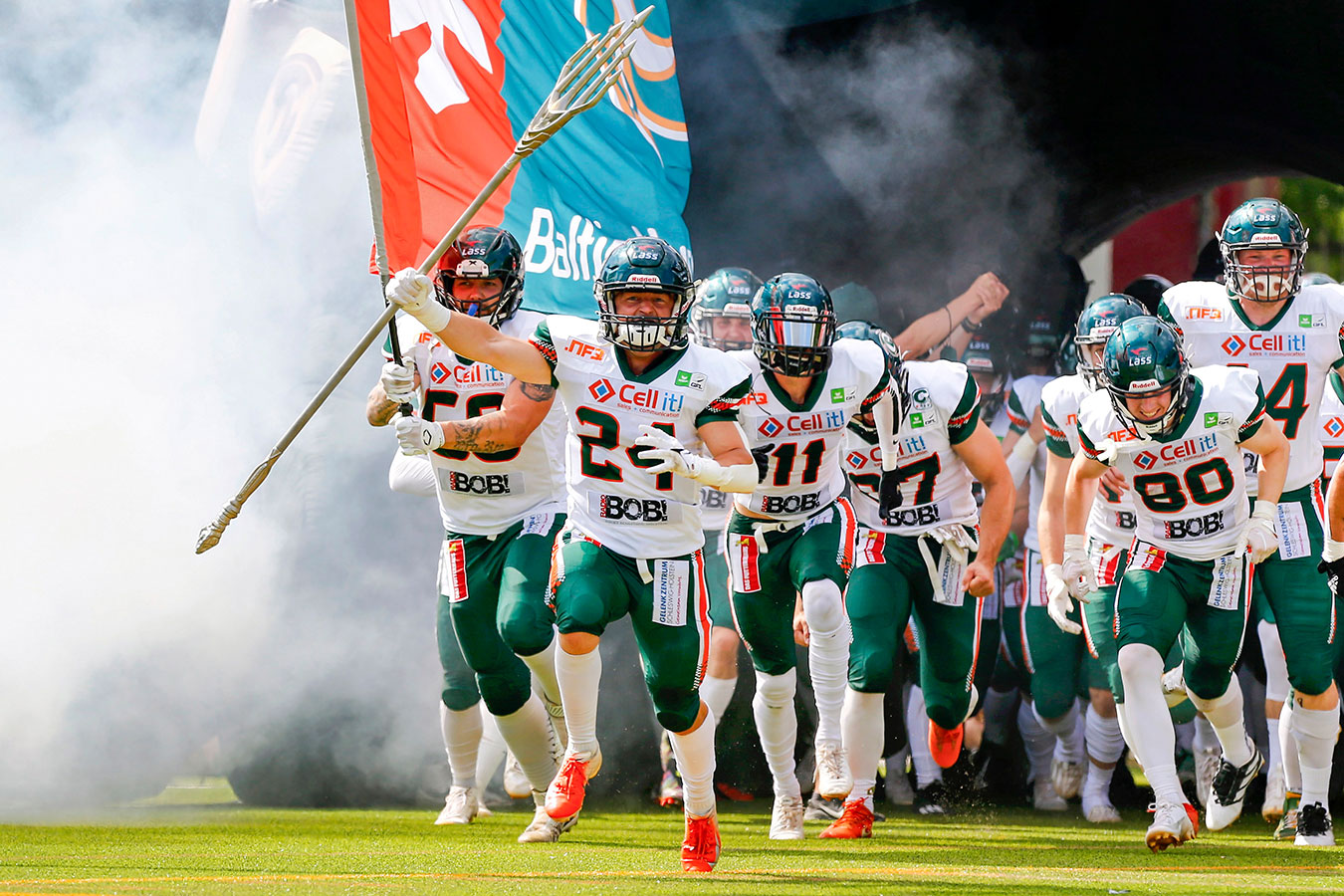 Das Team der Baltic Hurricanes läuft durch einen aufblasbaren Helm und durch Nebel ins Stadion ein. Angeführt werden sie von Nummer 24. Fritjof Richter, der den sogenannten Big Play Trident des Teams hochhält.
