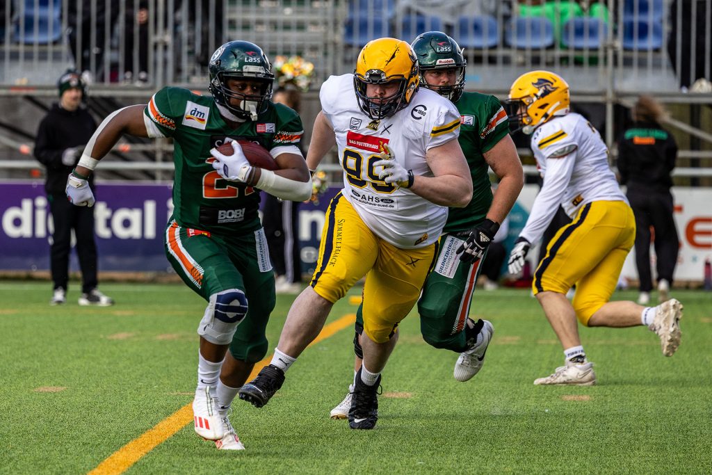 Running Back Emmet Ossei-Wusu läuft mit dem Ball, während ein Elmshorner Defense-Spieler ihm auf den Fersen ist.
